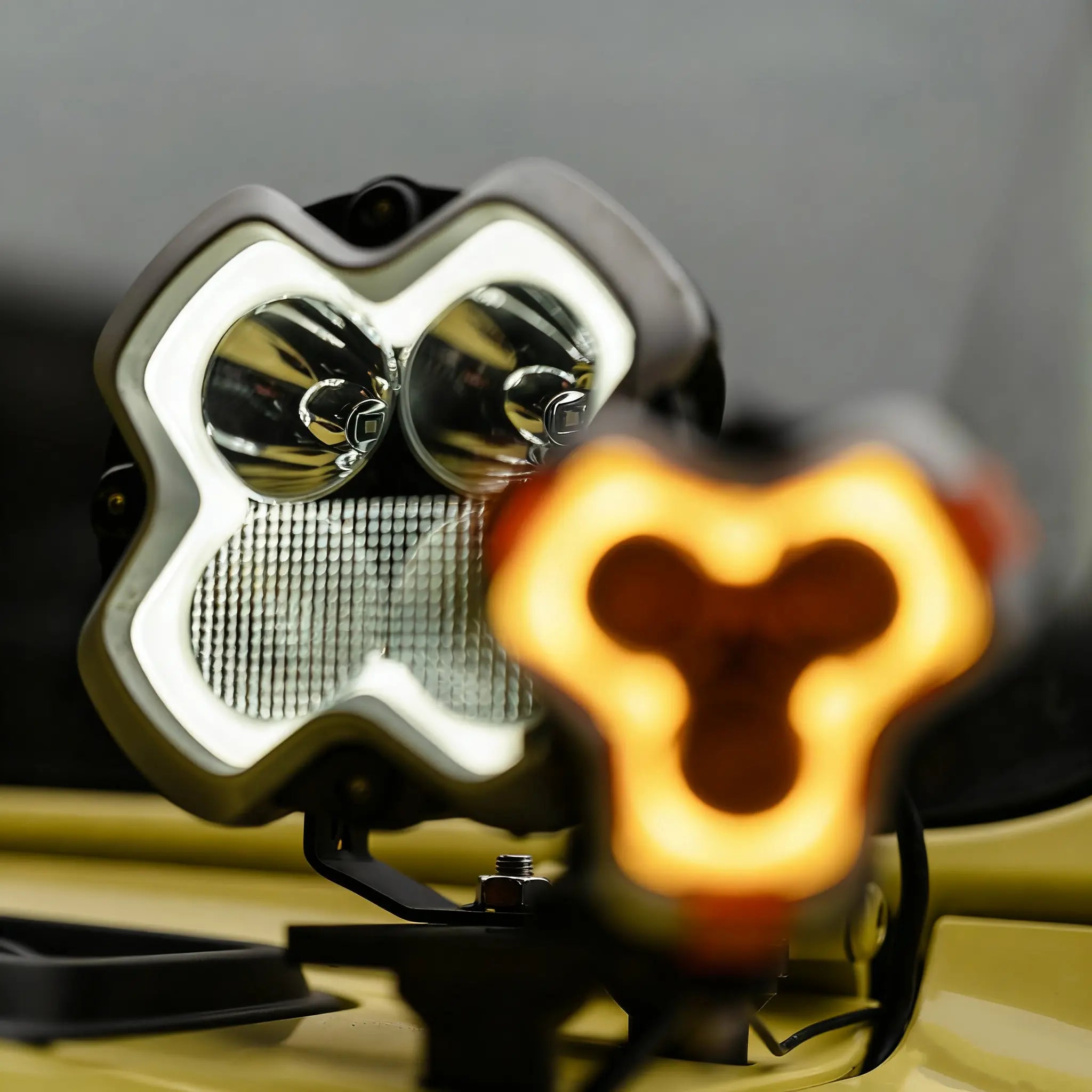 Close-up of a motorcycle headlight and turn signal with a blurred background