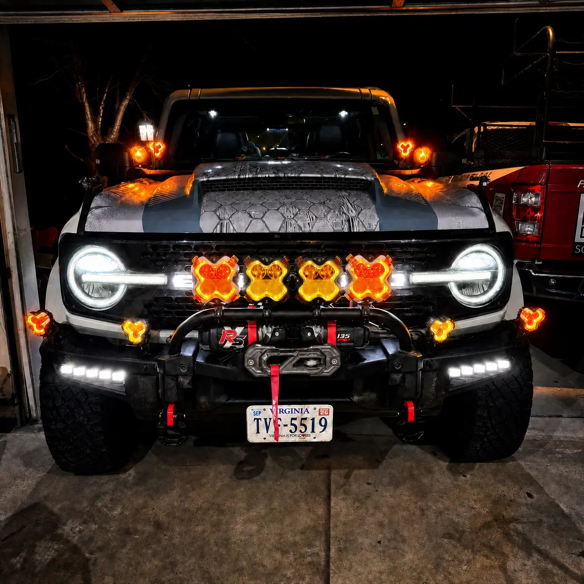 Front view of an off-road vehicle equipped with NOVSIGHT auxiliary lights in a garage